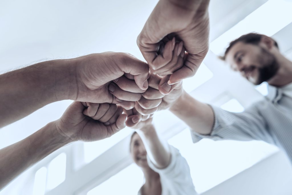 Team legt gemeinsam die Fäuste zusammen